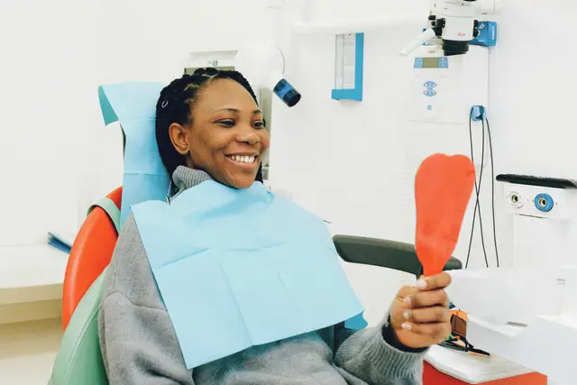 Sample stock photo: patient checking her smile in a mirror