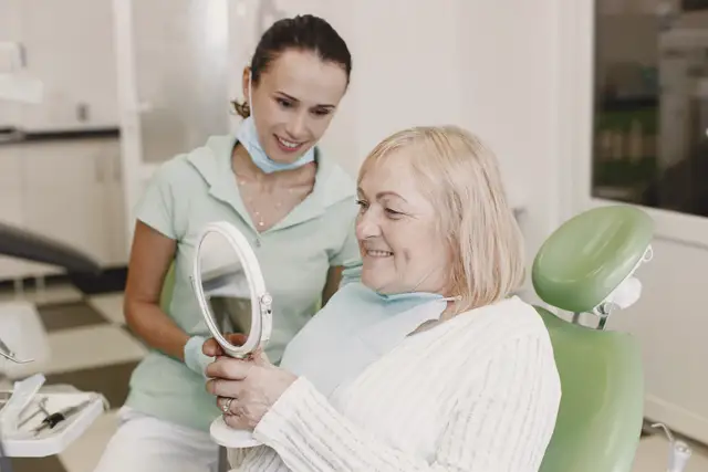 Sample stock photo: patient smiling into a hand mirror