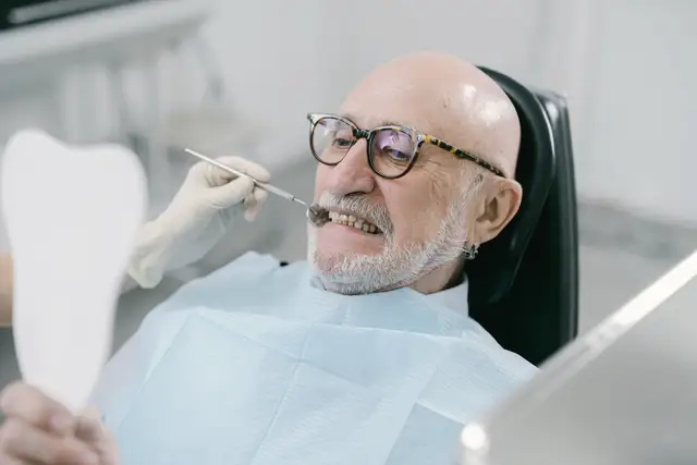 Sample stock photo: older man checking his teeth in a mirror